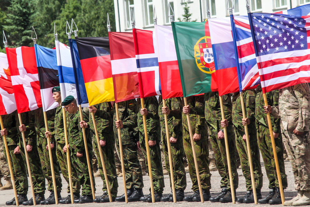 RUKLA, LITHUANIA - JUNE 8, 2015: NATO soldiers holding alliance flags