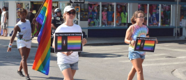 People marching in the Key West Gay Pride parade carry a memorial banner honoring those killed in the terror attack at the nightclub in Orlando, June 12, 2016. Credits: Chuk Wagner/Shutterstock